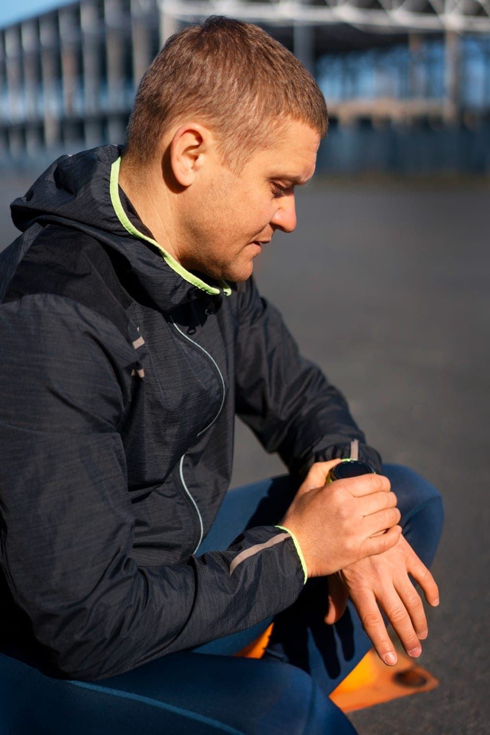 Coureur en tenue de running consultant sa montre GPS après avoir reçu sa séance PlaniTeam